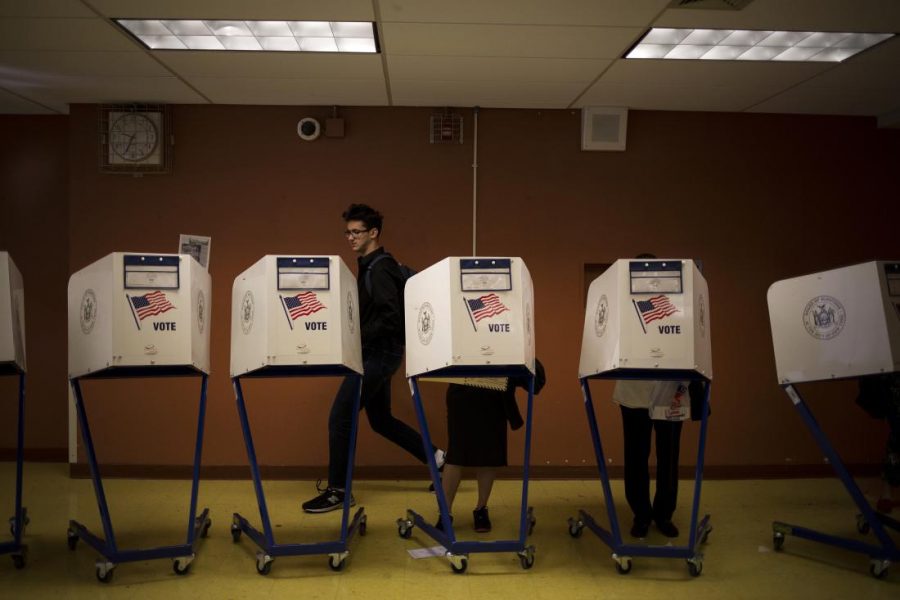 Residents cast ballots during the presidential primary vote at a polling location in New York, U.S., on Tuesday, April 19, 2016.